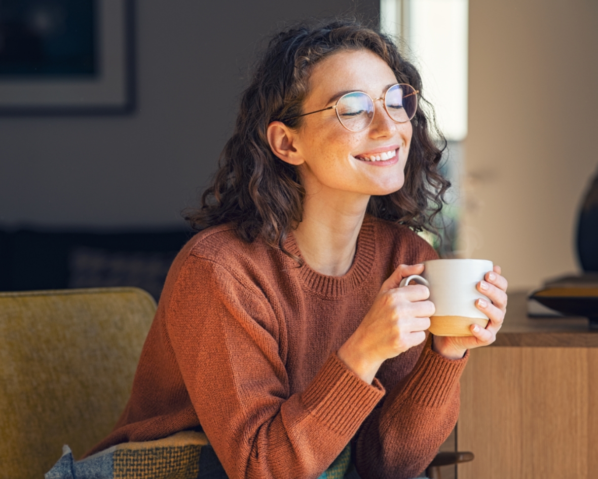 Kvinde drikker kaffe med enkeltstyrkebriller