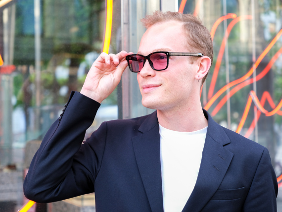 Simon Schill justerar sina färgskiftande glas utanför en Synsambutik.